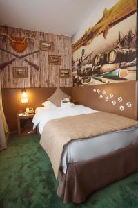 チュメニにあるVostok Hotelの大きなベッド付きのベッドルーム1室、壁に絵画が飾られています。