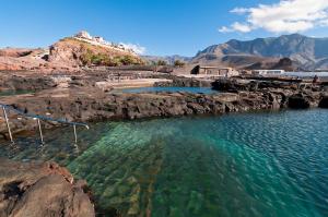 a body of water with rocks and a beach at Cozy House 5 min from the Historic Center of Galdar in Gáldar