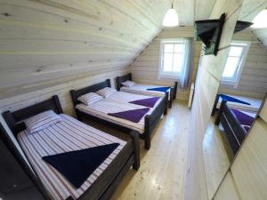 a room with three beds in a log cabin at Alkūnų sodyba in Molėtai +16 photos