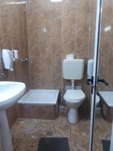 y baño con aseo, lavabo y ducha. en Complex Turistic Paralela'45, en Băicoi