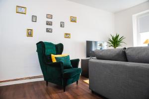 a living room with a green chair and a couch at St Pauli CITY Apartment in Hamburg