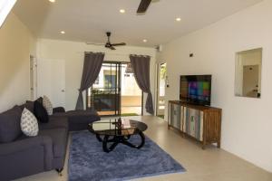 a living room with a couch and a tv at Aussieland Bungalows in Lamai