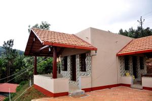 a small house with a red roof at Vamoose Kaddu Kallu in Kalasa