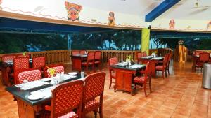a dining room with tables and chairs in a restaurant at Kappad Beach Resort in Kappad