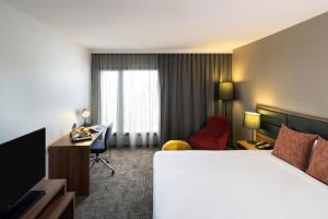 a hotel room with a bed and a desk at Novotel Sydney International Airport in Sydney