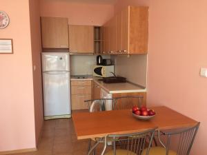 a kitchen with a table with a bowl of apples on it at Апартамент с две спални в комплекс Лъки 2 Свети Влас in Sveti Vlas