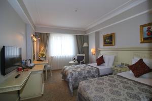 a hotel room with two beds and a television at Demir Hotel in Diyarbakır