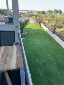 a balcony with a view of a green yard at Castella Apartments in Vourvourou