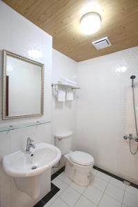 a bathroom with a sink and a toilet and a mirror at 安平72號民宿 in Tainan +45 photos