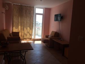 a living room with a couch and a tv and a window at Апартамент с две спални в комплекс Лъки 2 Свети Влас in Sveti Vlas