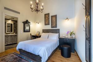 Un dormitorio con una cama grande y una lámpara de araña. en Hotel Antique, en Ioannina