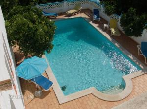 an overhead view of a swimming pool with two chairs and an umbrella at Vila Sodré Guest House in Silves