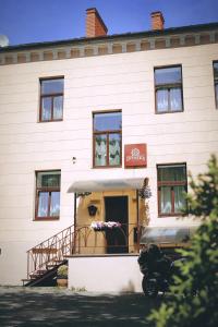 a white building with a door and a balcony at Apartamenti DVINSKA in Daugavpils