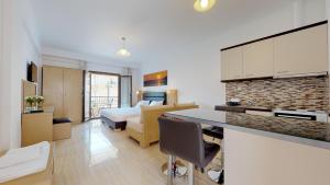 a room with a kitchen and a bedroom with a bed at Valentinos House in Parga