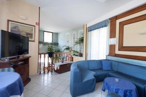 a living room with a blue couch and a tv at Hotel Nella in La Spezia