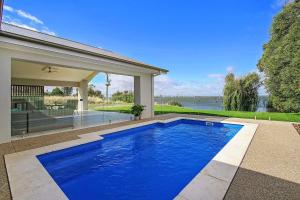 ヤラウォンガにあるWoodbine Waters Lakehouseの家の前の青いスイミングプール