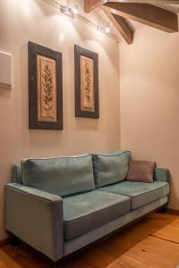 a green couch in a room with two pictures on the wall at Hotel Antique in Ioannina