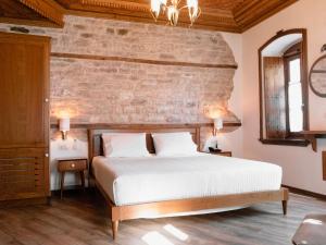 a bedroom with a bed and a brick wall at Argjiro Traditional in Gjirokastër