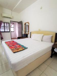 a bedroom with a large bed with white sheets at Star Lodge in George Town
