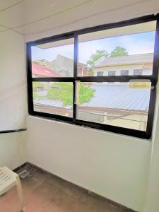 a room with two windows and a white chair at Star Lodge in George Town