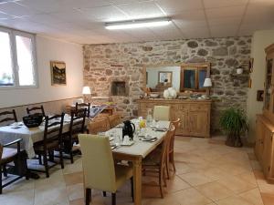 a dining room with tables and chairs and a stone wall at Mirabelle Bed & Breakfast in Ribeauvillé