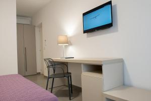 Pokój z biurkiem i telewizorem na ścianie w obiekcie Casole Living B&B w mieście Copertino