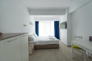 a small bedroom with a bed and a window at ZIP Apartments in Mamaia +68 photos