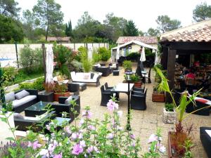 a garden with couches and tables and flowers at Bungalow Claret in Vacquières