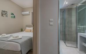a bedroom with a bed and a glass shower at Cosy apartment in the heart of the city centre in Zakynthos