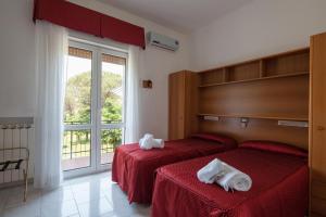 una camera d'albergo con due letti e asciugamani di Hotel Nella a La Spezia