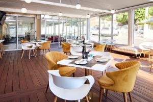 un restaurante con mesas, sillas y ventanas en First Group Mount Sierra, en Ciudad del Cabo
