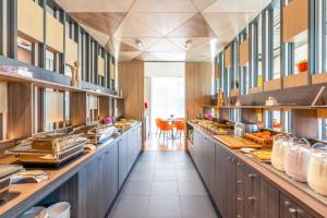a large kitchen with a long line of counters at Hotel Sophia by Tartuhotels in Tartu