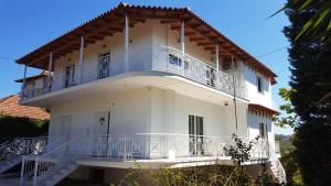 a white house with a large balcony on top of it at Villa Fotini I in Amalias
