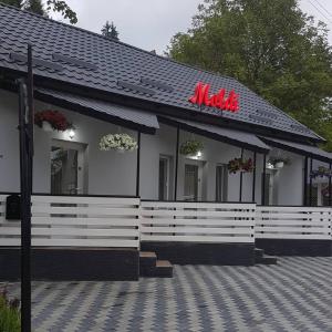 um restaurante com uma placa na lateral de um edifício em Cazare Moldi Btt em Câmpulung Moldovenesc