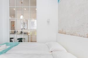 a bedroom with a white bed and a painting on the wall at Apartments Gdańsk Starowiejska by Renters in Gdańsk