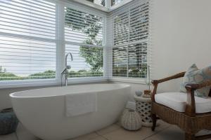 a bath tub in a bathroom with a window at Grootbos Private Nature Reserve in Gansbaai