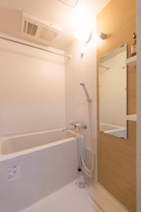 a bathroom with a bath tub and a mirror at YUYU ShinSai YuuJinChou 悠悠心斋桥友人帐主题酒店 in Osaka