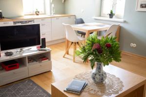 a living room with a vase of flowers on a table at Silbernagel Apartment in Kuressaare