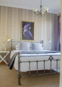 1 dormitorio con 1 cama con una foto en la pared en Mataura Lodge Athol en Athol