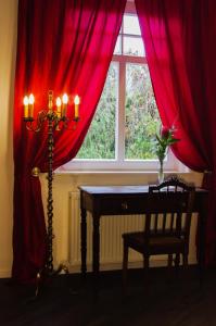 a room with a table and a window with red curtains at Villa Wilmarie in Rottweil
