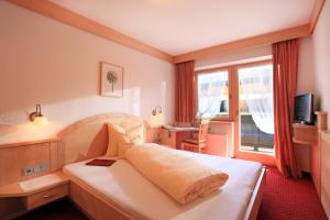 Habitación de hotel con cama y ventana en Hotel Eggerwirt en Söll