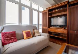 sala de estar con sofá y TV en Apartamento Paseo Maritimo 27, en Cádiz