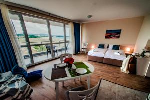 a hotel room with a bed and a table with flowers at Zornitsa Apart in Primorsko +66 photos