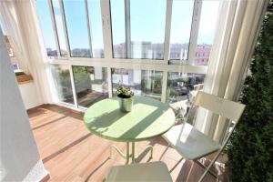 - Balcón con mesa verde y 2 sillas en 325 Agata Apartamentos - Piscina y Playa -CANALES DE TV INTERNACIONALES, en Benalmádena