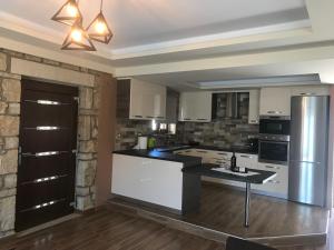 a kitchen with white cabinets and a black counter top at Panoraia Maisons in Margariti