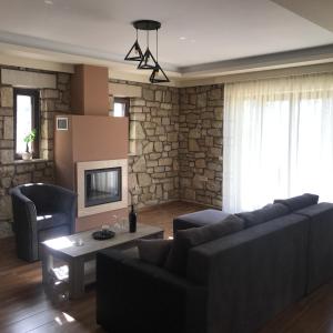 a living room with a couch and a tv at Panoraia Maisons in Margariti