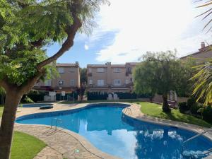 einen Pool in einem Innenhof mit Bäumen und Gebäuden in der Unterkunft Apartamento Altafulla in Altafulla