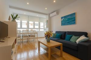 a living room with a blue couch and a table at Casa Ros-PLAYA free parking by Cadiz4Rentals in Cádiz