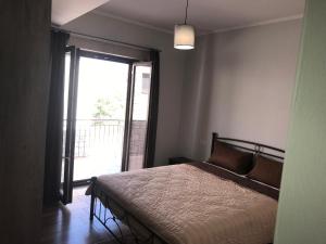 a bedroom with a bed and a large window at Panoraia Maisons in Margariti