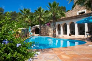 una piscina frente a una casa con palmeras en Casa Granada at Masia Nur Sitges, with private pool and adults only, en Canyelles